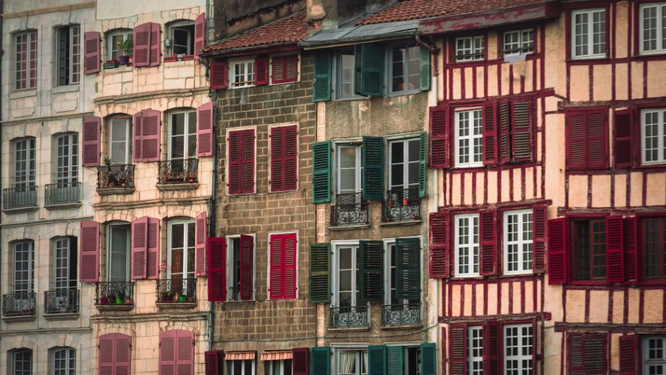 Façades traditionnelles à Anglet Ensemble de façades traditionnelles à Anglet avec des volets colorés et des balcons décorés, illustrant l'architecture locale typique.